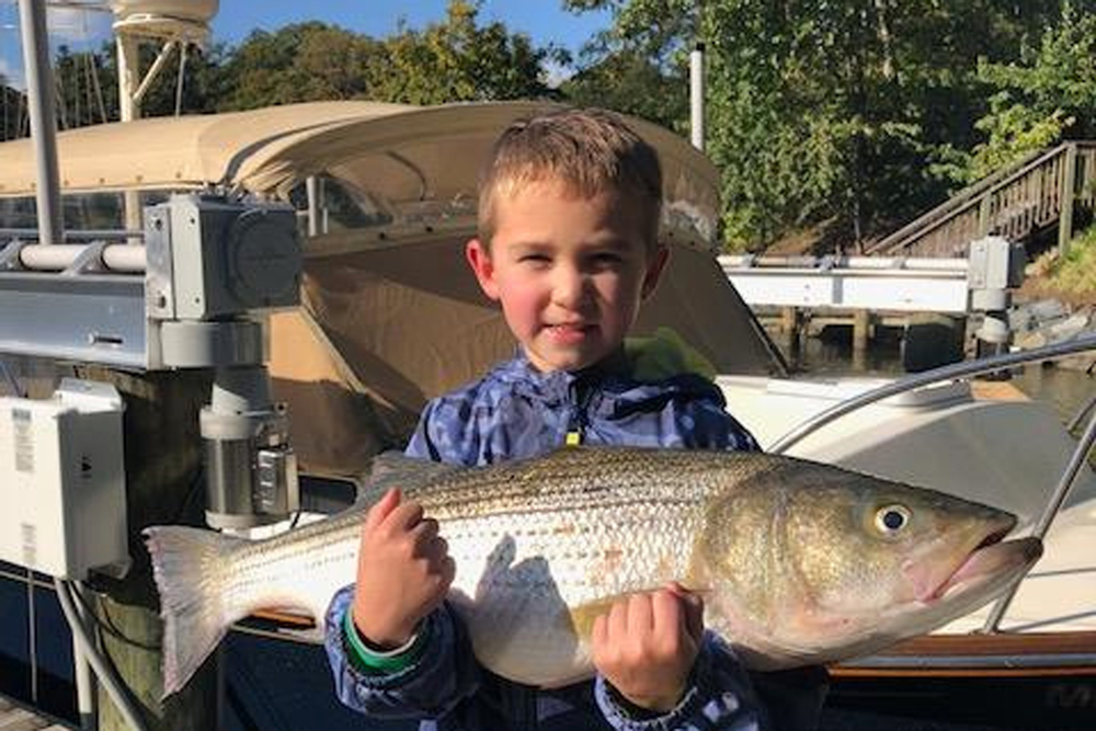 kid with striped bass