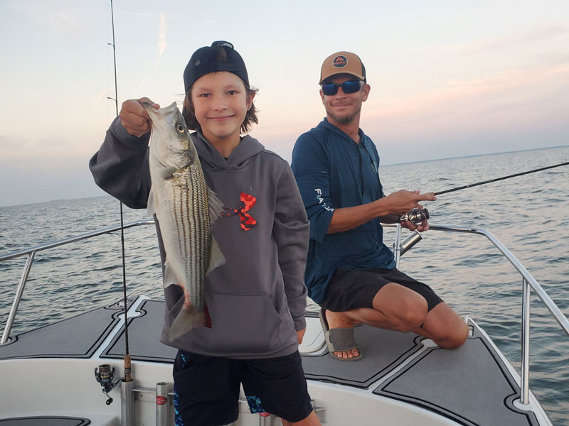 a kid with a striped bass caught in chesapeake bay