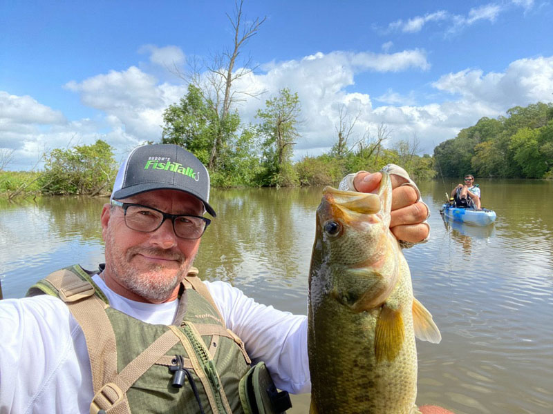 angler holds up a largemouth bass