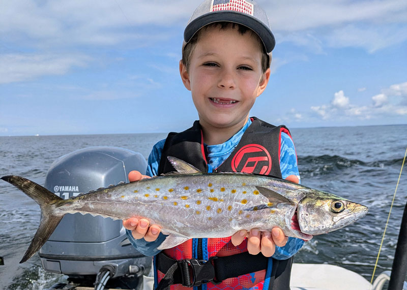 kid holding up a spanish mackerel